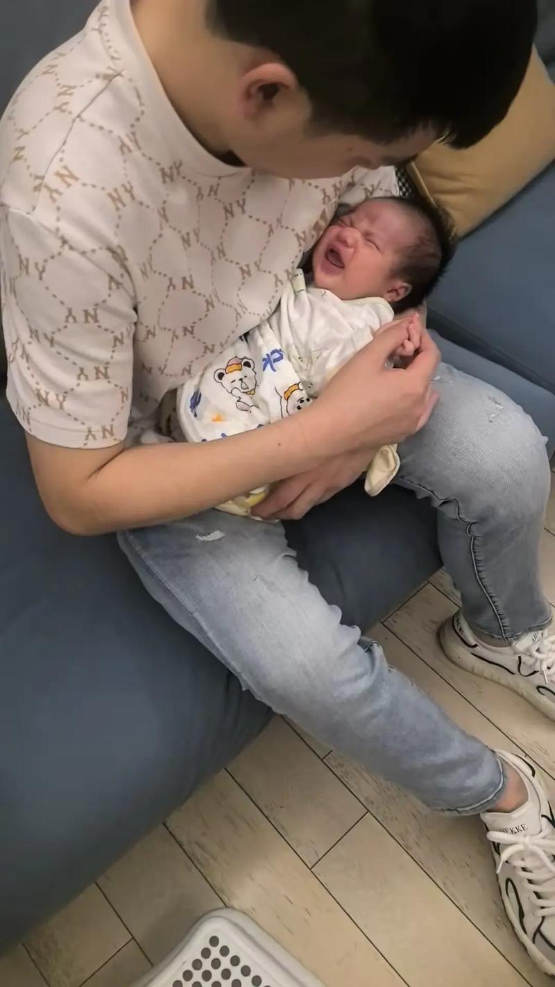 深夜房间里疲惫的新手爸爸抱着哭闹的婴儿