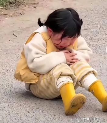 家长蹲下来安抚游乐场摔倒哭的小朋友