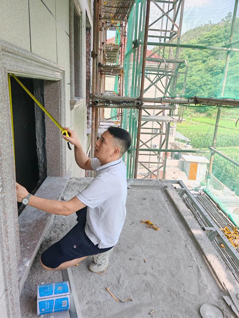 门窗安装工人正在用红外线水平仪校正窗框垂直度
