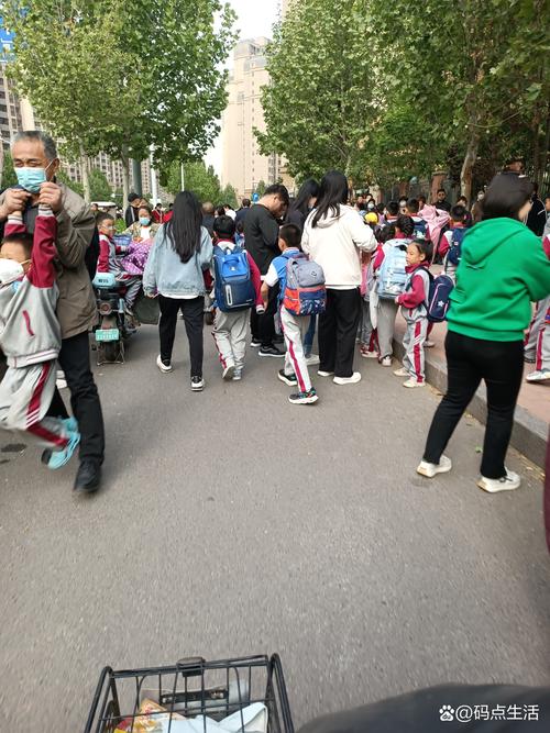 小学门口家长接孩子看试卷场景