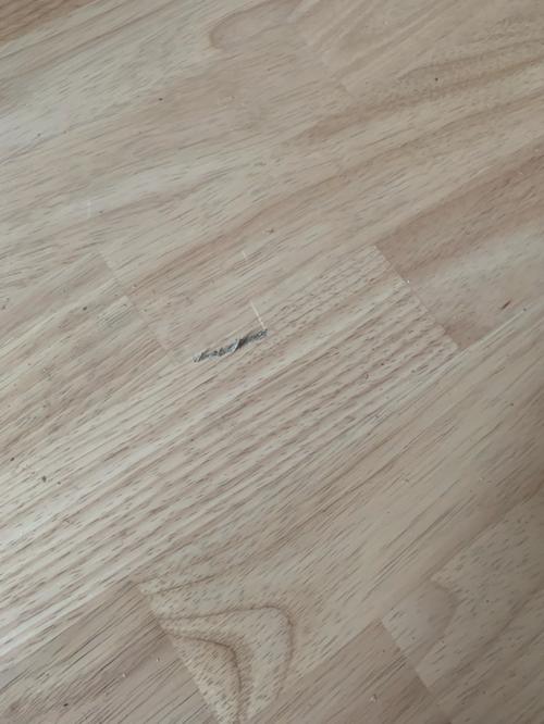实木地板上留着奶白色小圆圈形状的奶渍痕迹