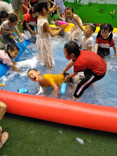 幼儿园老师陪孩子光脚踩水互动场景