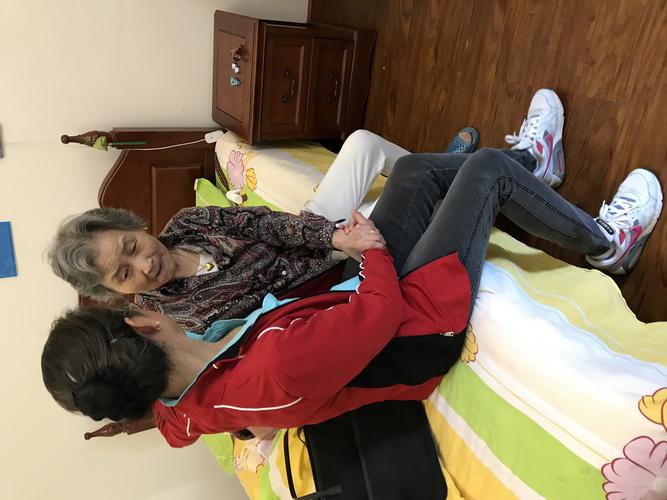 退休阿姨和残障儿子阳台晒太阳的日常场景
