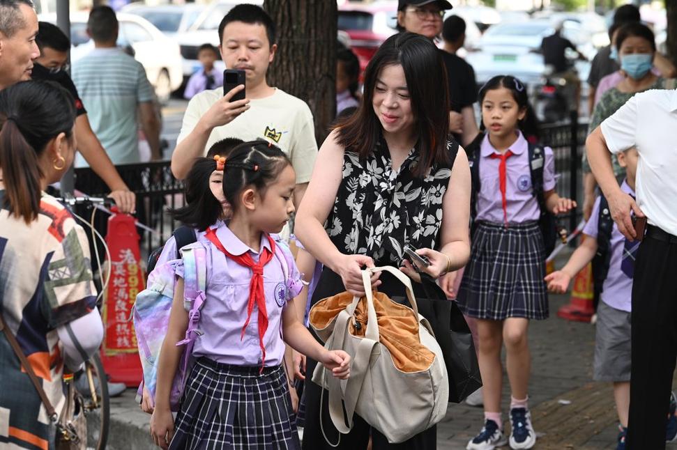 小学家长学校门口接孩子聊学习场景