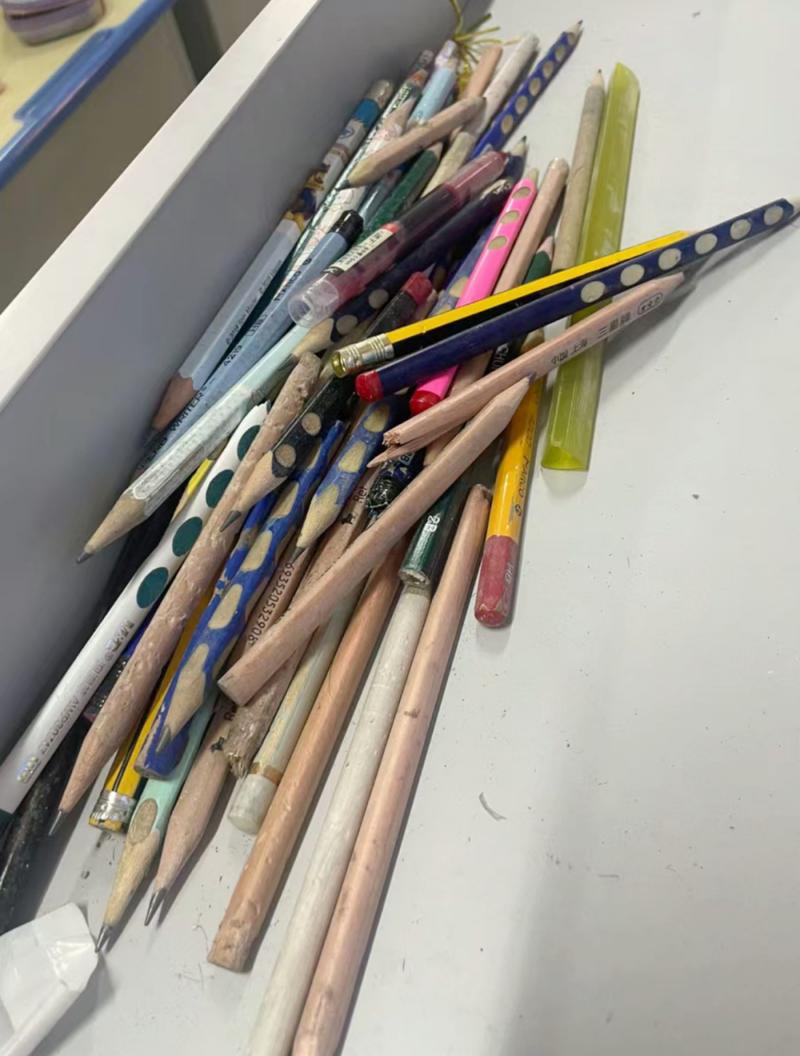 小学低年级孩子写作业时桌面散落橡皮铅笔的实拍场景