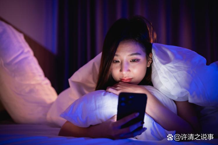 深夜青年侧躺在床上玩手机屏幕幽暗