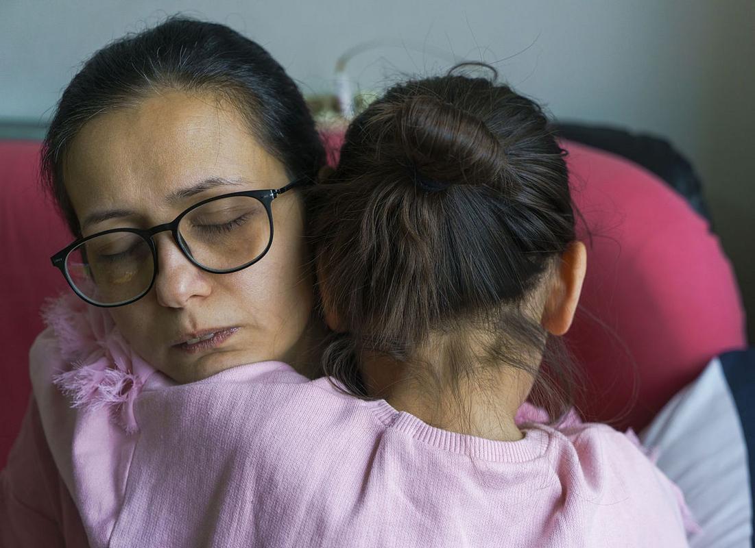 孩子递给哭泣妈妈纸巾的温馨家庭场景图
