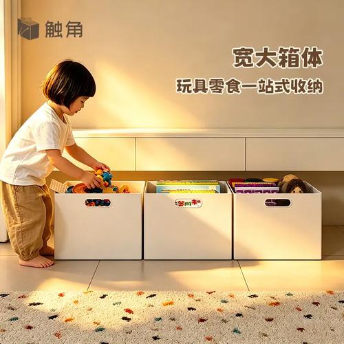 家长蹲下来跟幼儿视线齐平说话 旁边放着玩具收纳筐