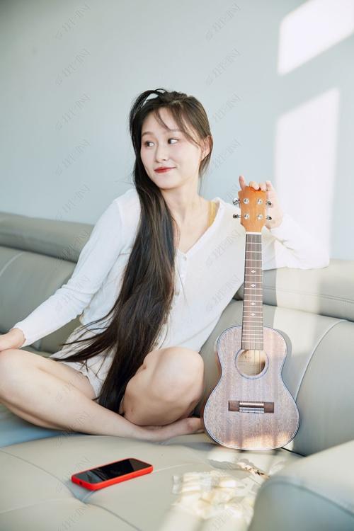 沙发上随意弹尤克里里的人