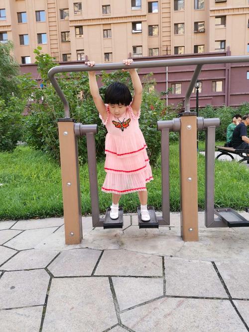 小区露天健身台阶靠护栏站的小女孩