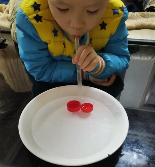 两岁幼儿执着于自己拧矿泉水瓶盖的居家日常实拍图