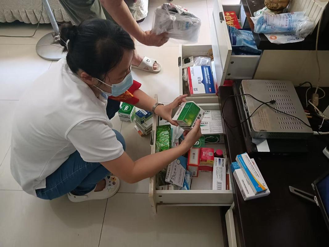 老人整理家用过期药品药箱现场