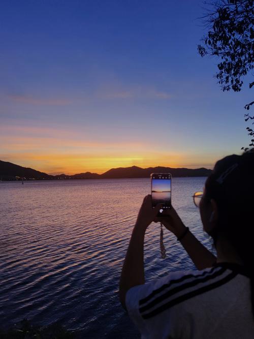 Vlogger手持稳定器在日落海边拍摄场景
