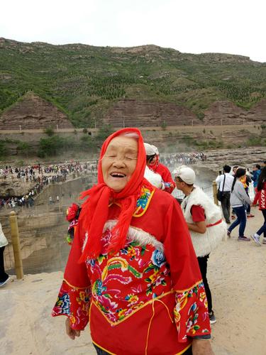 龙门石窟伊河岸边挎杜康布包的本地老人