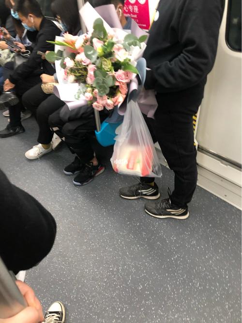 城市地铁站口年轻人手持鲜花下班场景