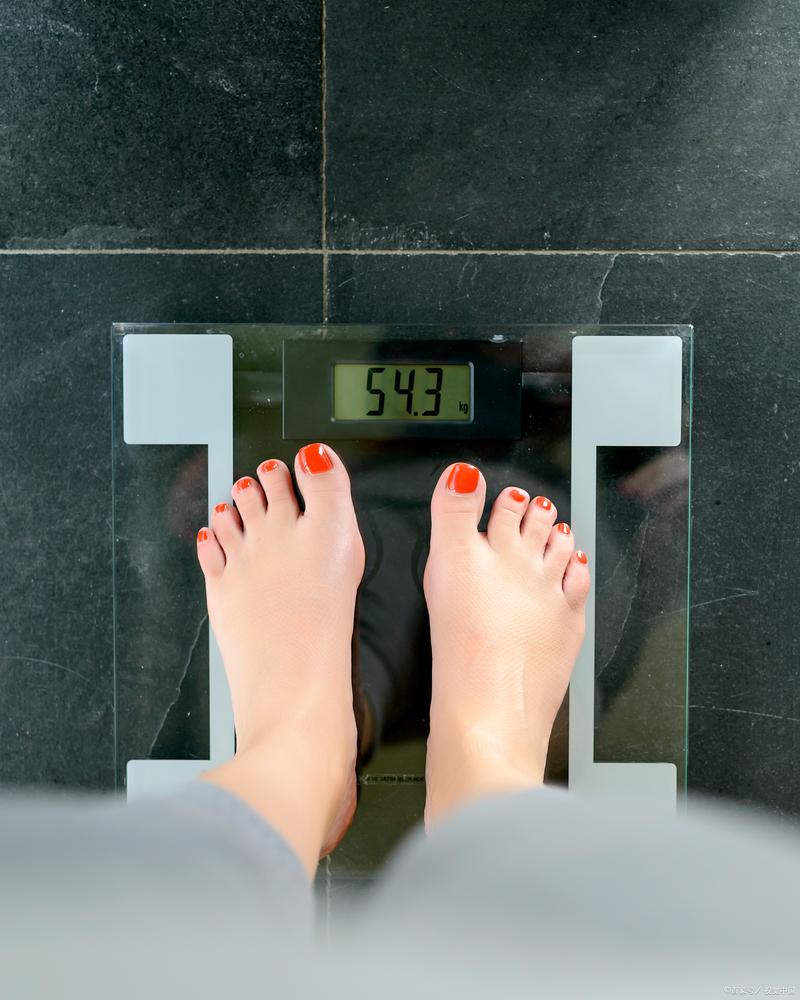减肥女子站体重秤上沮丧