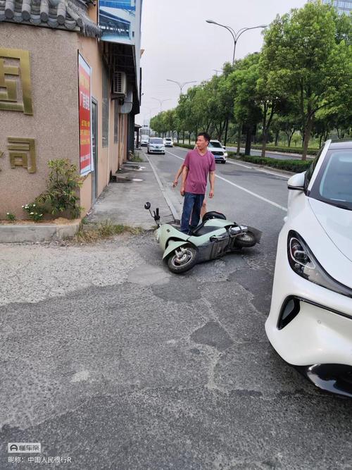 电动车避让流浪猫剐蹭路边停放车辆现场图