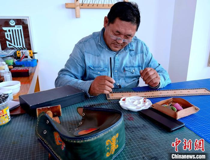 响沙湾景区内少数民族同胞展示皮雕手作现场