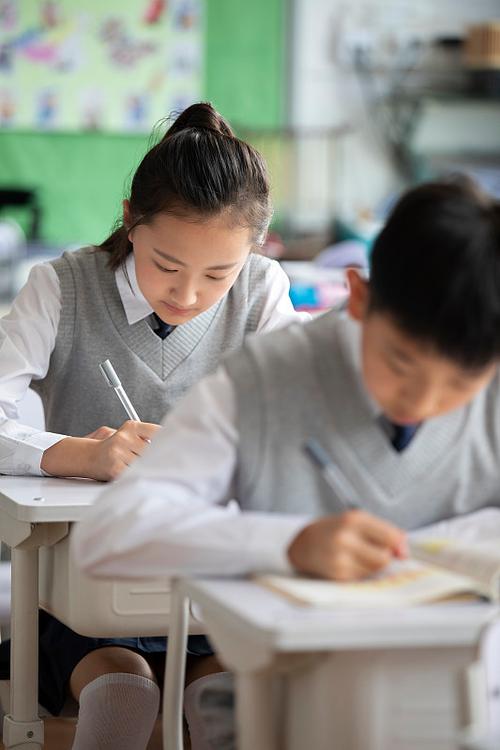 中小学课堂学生低头写思考笔记场景