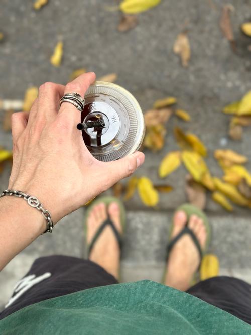 人攥着玻璃杯站在路边平复情绪的实拍
