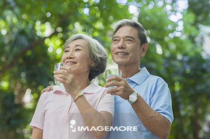 散步途中喝水休息的老年夫妇