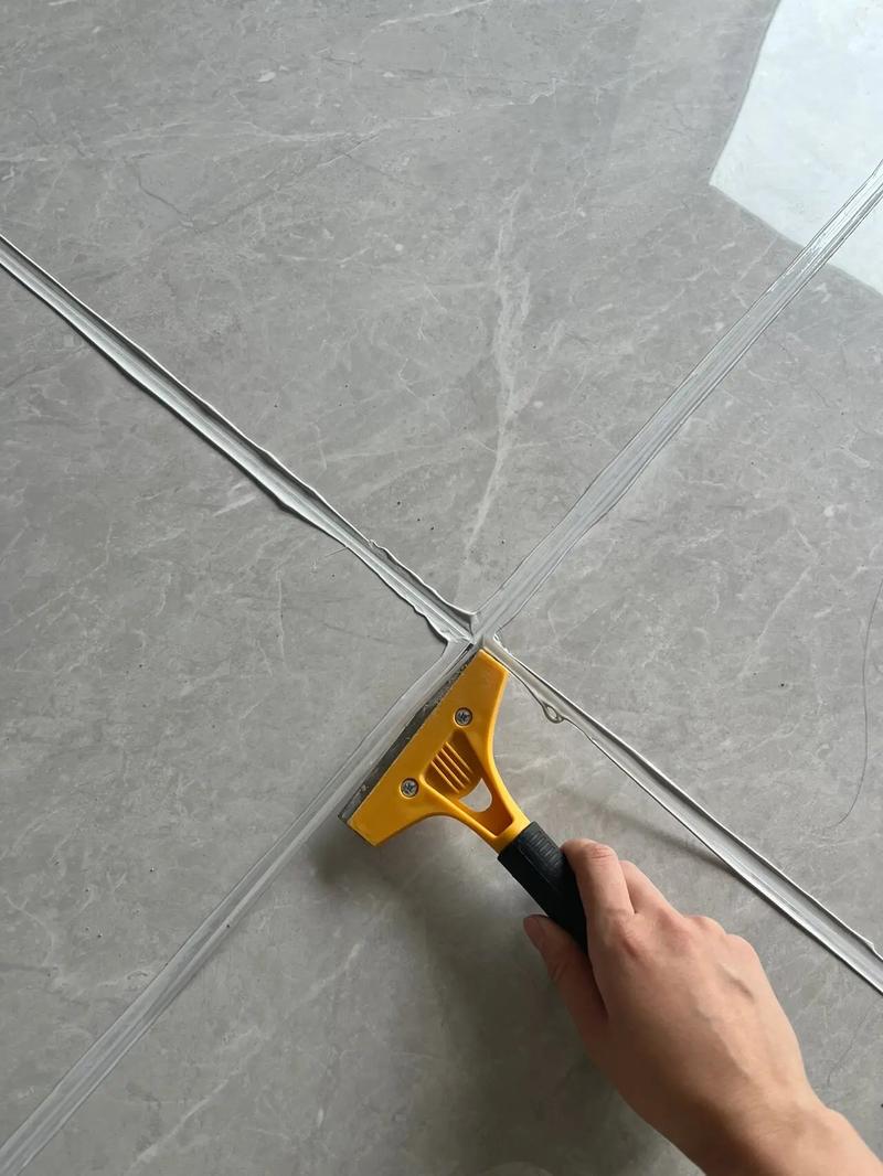 装修工人正在用压缝工具做环氧彩砂美缝