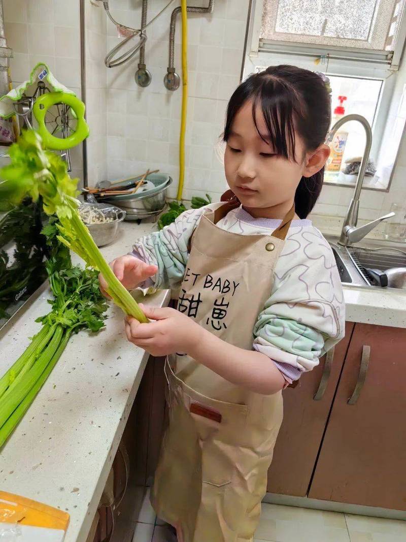 儿童在家帮家长择菜参与食育活动照片