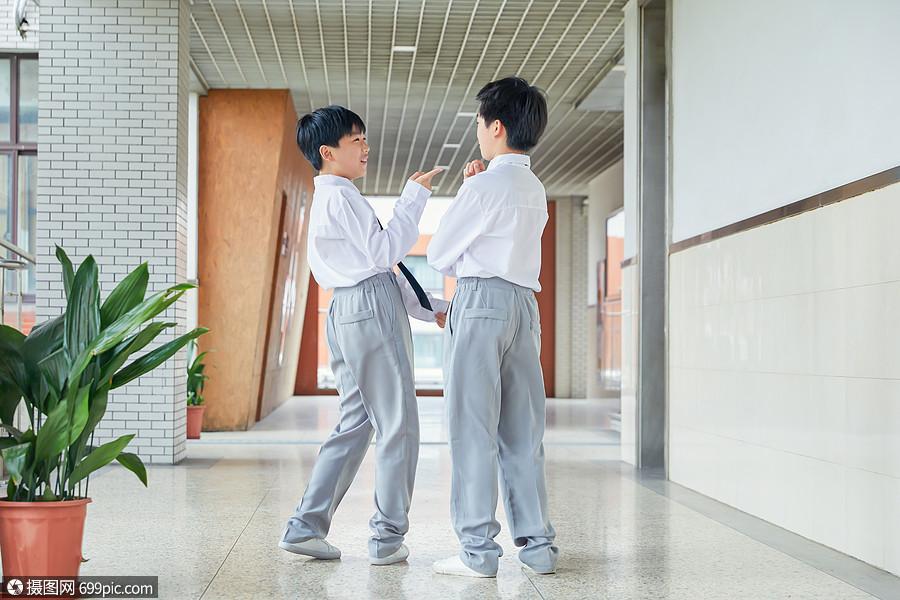 小学走廊上女学生凑在一起说悄悄话的实拍