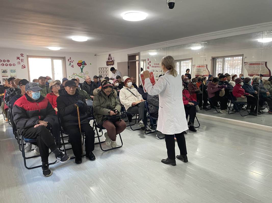 退休老中医在社区给老人讲日常健康常识的现场场景