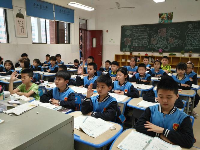 小学生课堂举手回答标准化试卷场景
