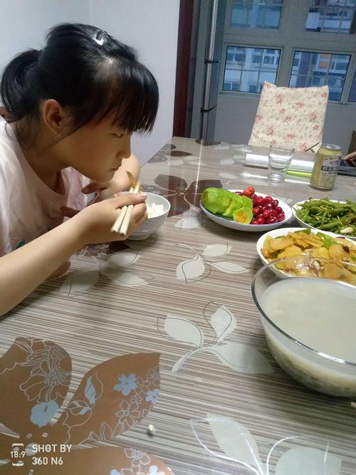 晚饭桌边妈妈和小学孩子聊天的日常实拍