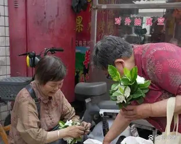 小区门口卖栀子花的阿婆木制推车