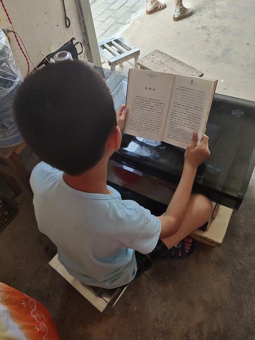 小学门口传达室蹲坐看书的流动儿童