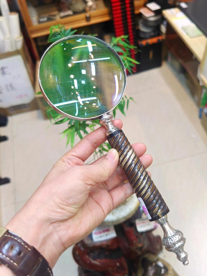 收藏者在灯下用放大镜观察旧徽章