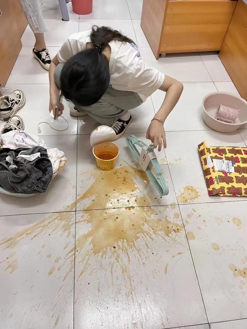 幼童蹲在客厅瓷砖上用湿纸巾擦拭洒在地上的橙汁