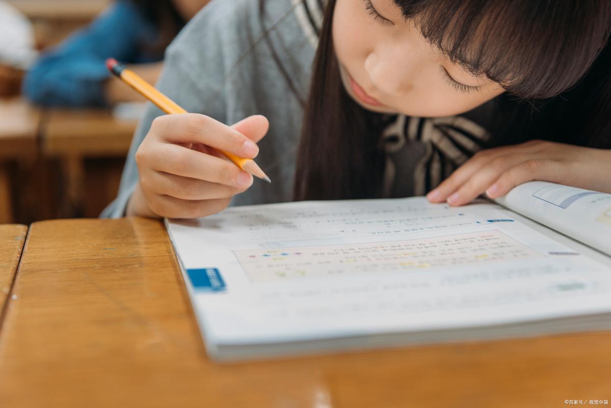 小学课桌旁学生低头抠橡皮的手部特写