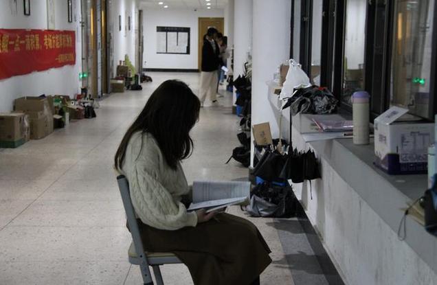 考研学生深夜在图书馆走廊背书
