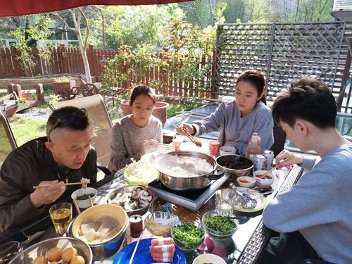 亲子在露天小火锅边开心吃饭的实拍