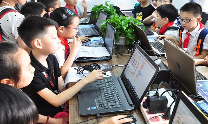 小学生操作乐高机器人编程课堂实景