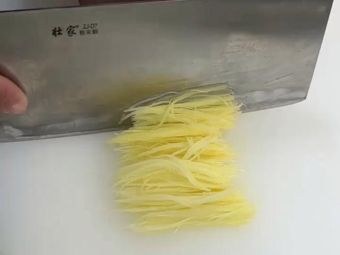 中式厨房里正在切姜丝的场景,砧板上散落姜片