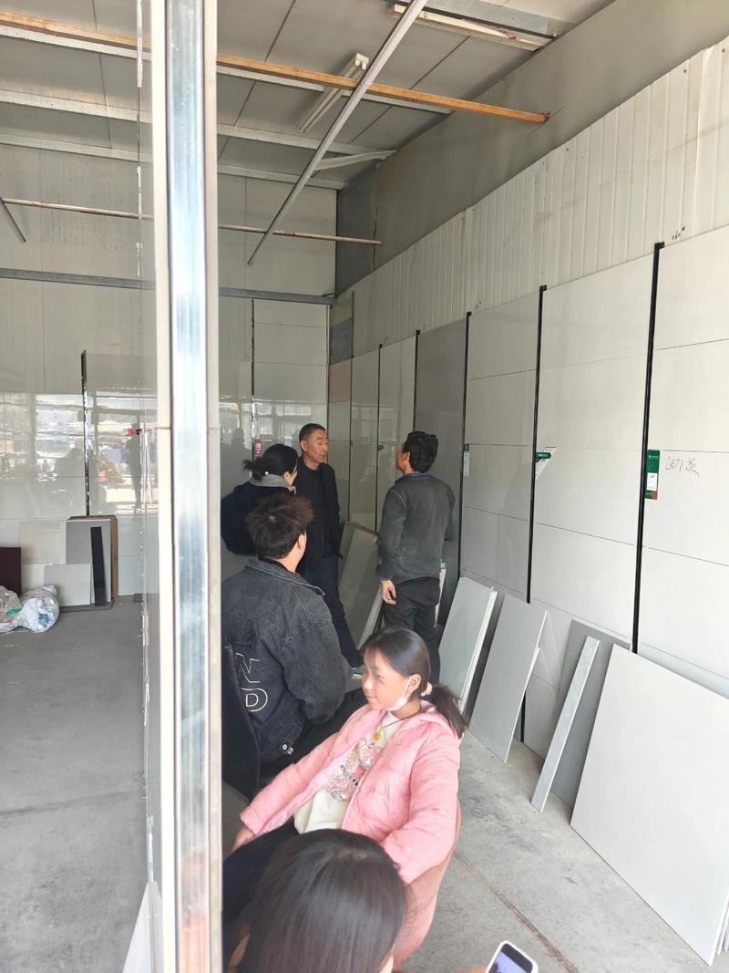 建材店老板蹲在仓库核对瓷砖质量场景