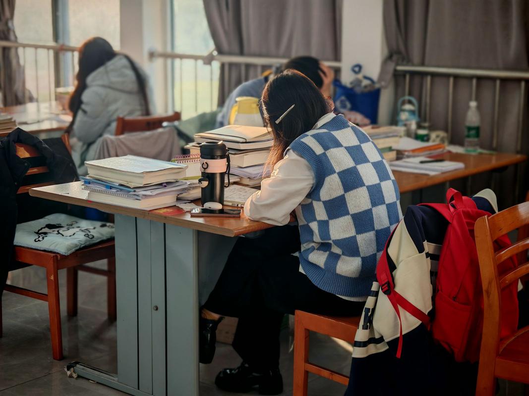 医学考研女生在堆满书籍的自习室熬夜学习