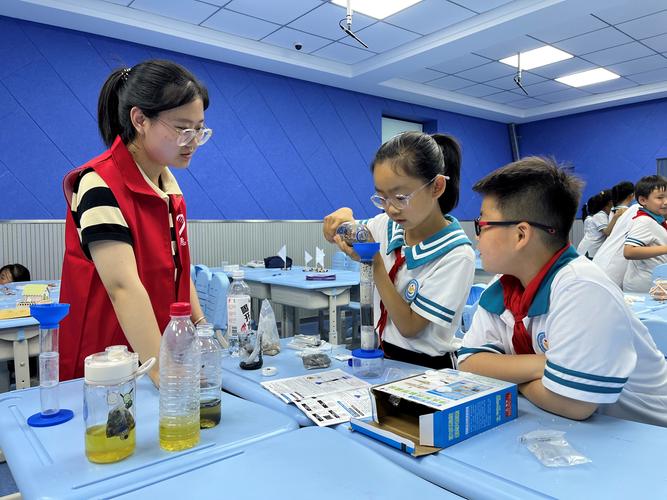 小学生围坐在一起动手做水净化实验的课堂场景