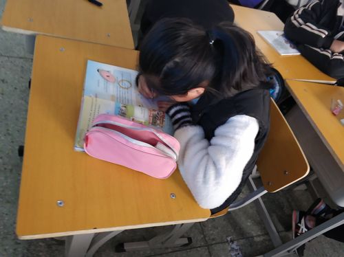 初中数学课堂后排学生低头攥半块橡皮的特写