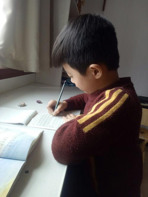小学生书桌摊开作文本抓头发照片