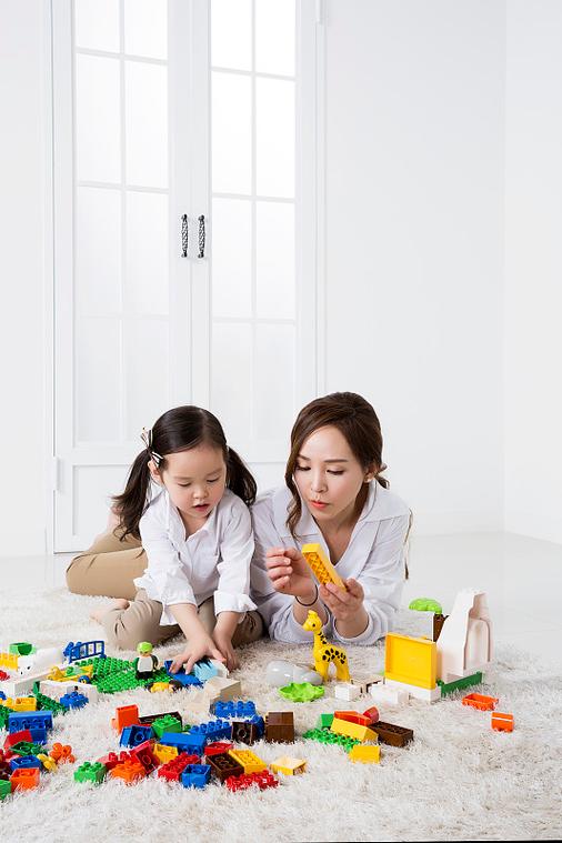 18个月婴儿被妈妈抱着玩积木的居家实拍