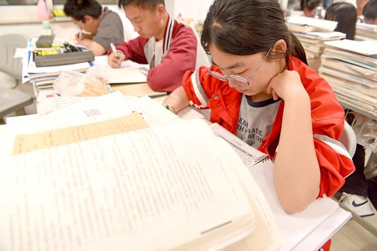 高中生站在学校走廊窗边背单词