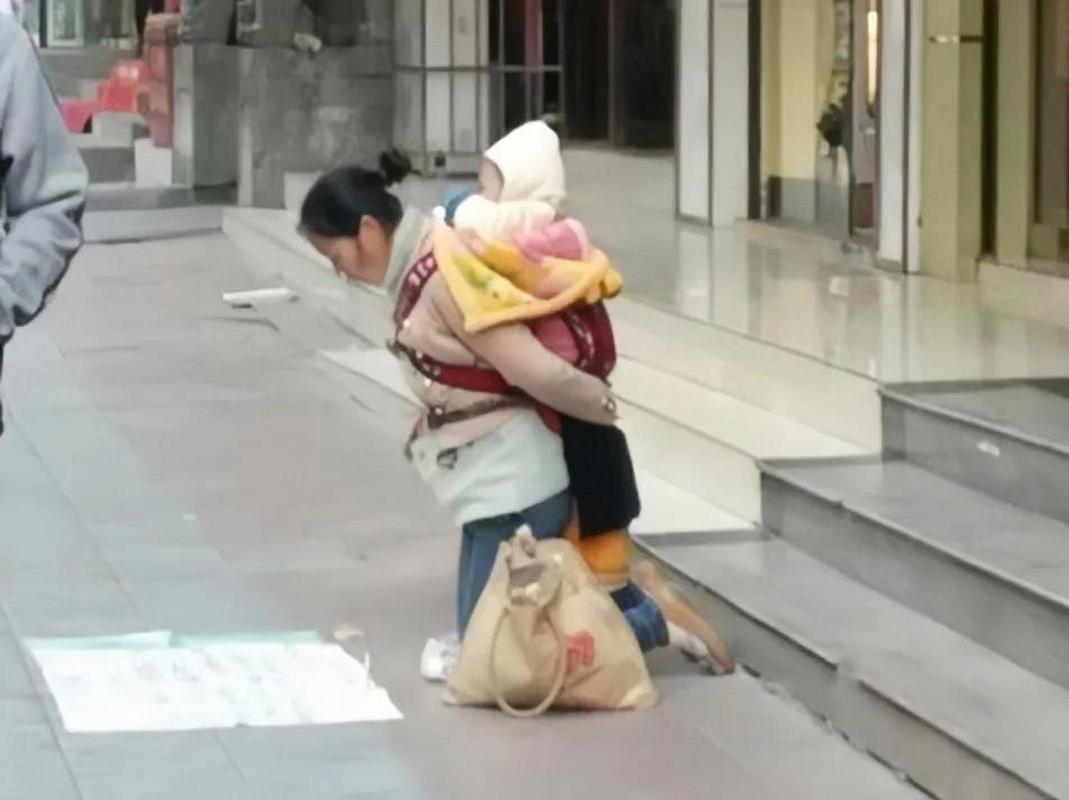 两岁幼儿蹲在小区路边哭闹家长蹲在旁边安抚的实拍图