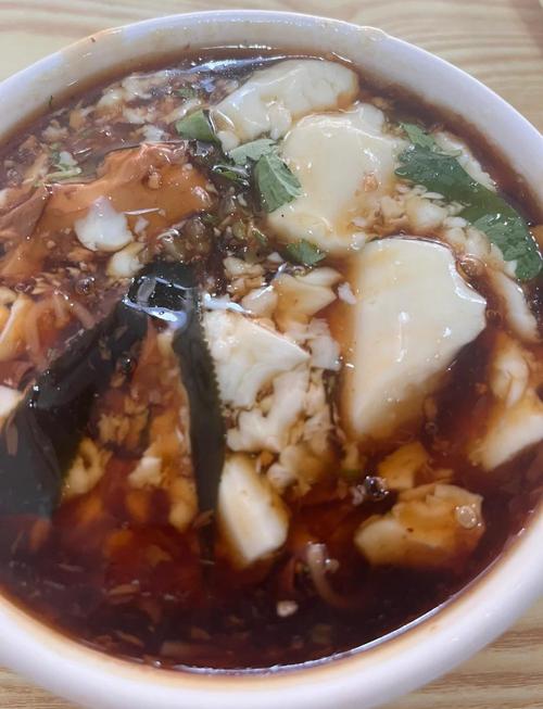 平原老豆腐摊主铜勺沿碗边浇卤的实拍
