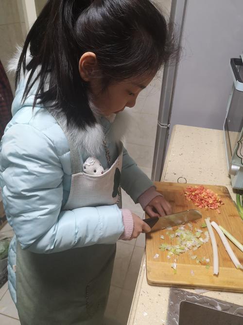 三年级小朋友帮妈妈切腌萝卜案板场景